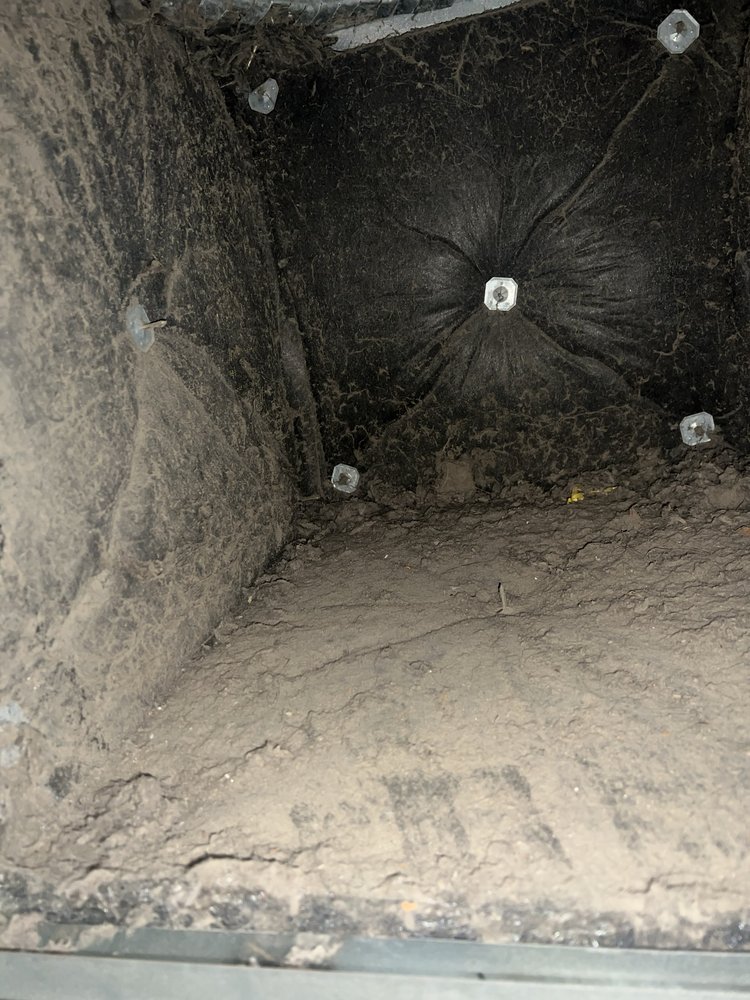 Dirty black insulation inside HVAC ducts before cleaning in Oakland, CA