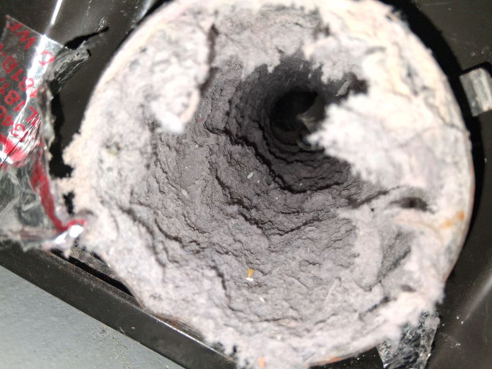 Coated vent tube buildup before air duct restoration in Oakland, CA